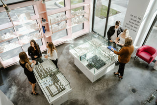 Six people stand around in the Perrara jewelry store in Kelowna while shopping for engagement rings and wedding bands.