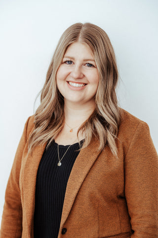 One of the Perrara sales associates, with light blonde hair, wearing a black shirt and brown blazer.