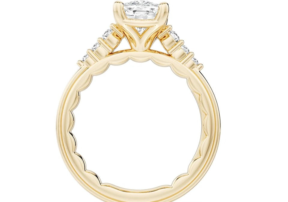A yellow gold engagement ring setting seen in profile, with its matching band