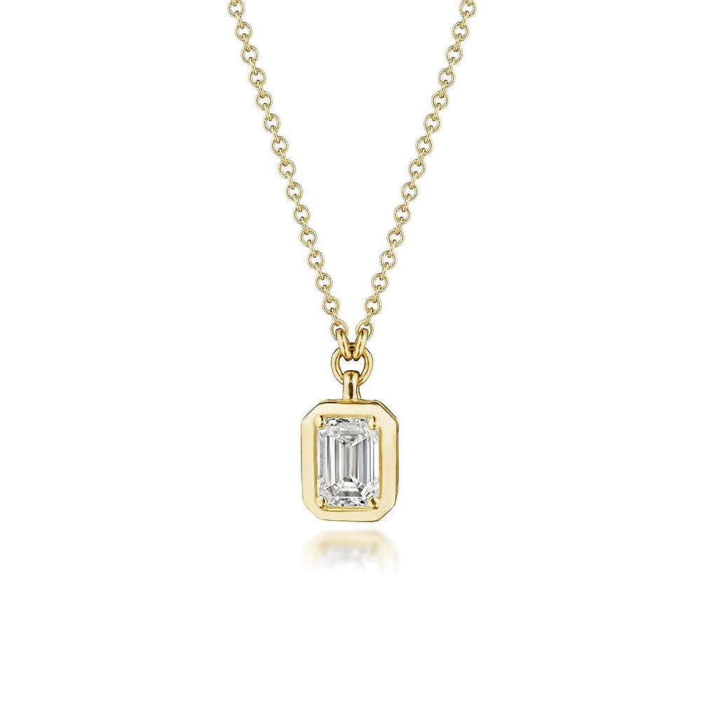An emerald cut diamond pendant necklace in yellow gold