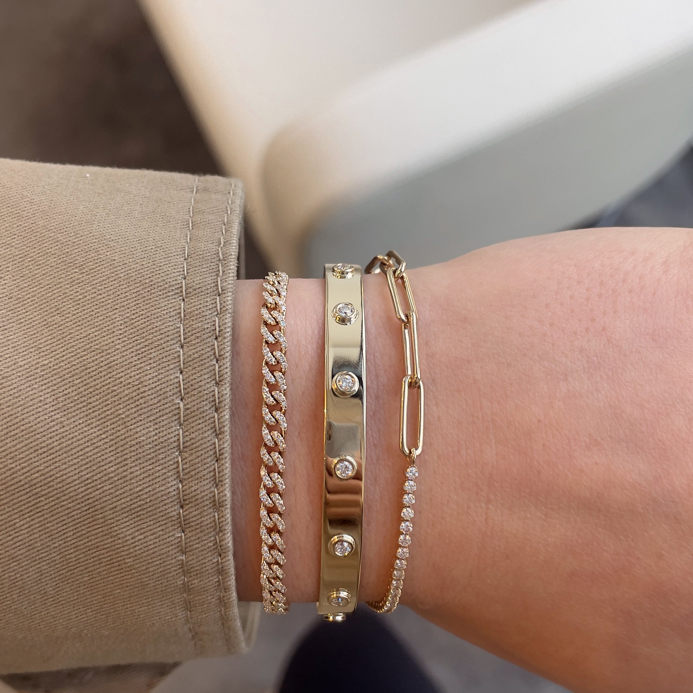 Gold bracelets stacked on the wrist