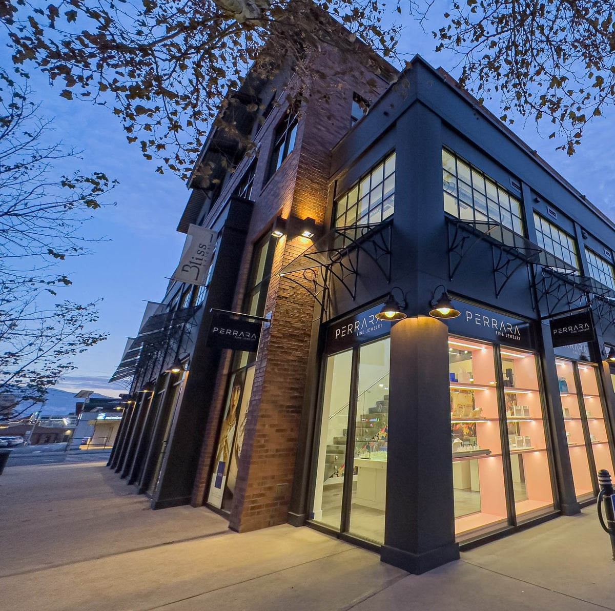The Perrara Fine Jewelry storefront on KLO Road in Kelowna at dusk, pink shelves lit in the windows