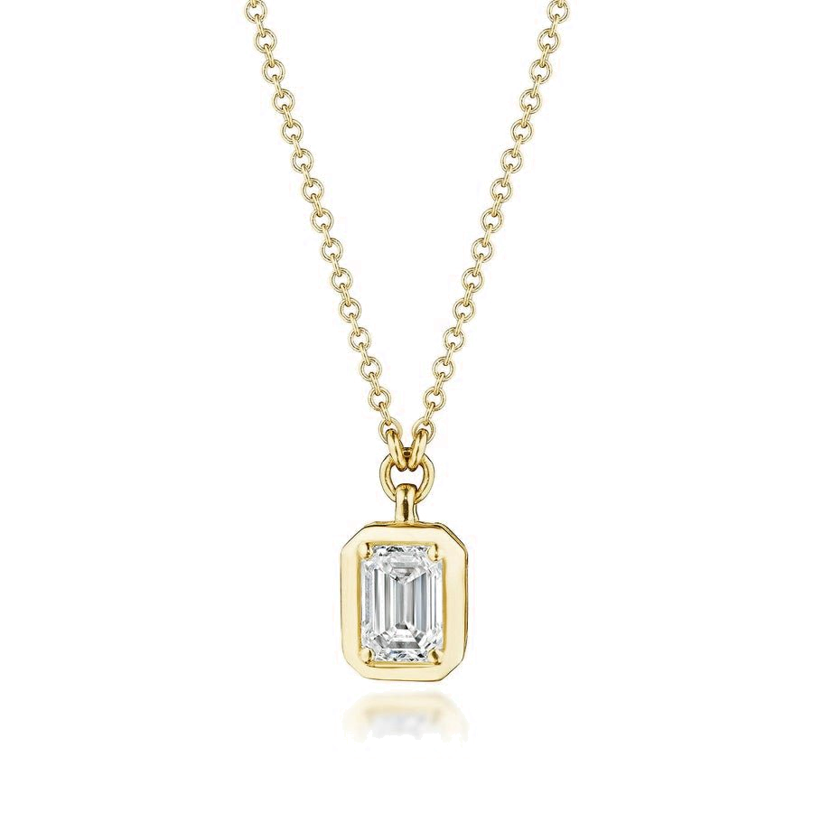 An emerald cut diamond pendant necklace in yellow gold